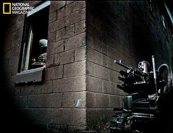 Ready to fire bullets and hurl grenades, a Modular Advanced Armed Robotic System, operated by a soldier behind cover, rolls into action in a training setup at Fort Benning , Georgia.